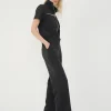 din profil, set negru cu jachetă cu guler înalt și pantaloni drepți largi