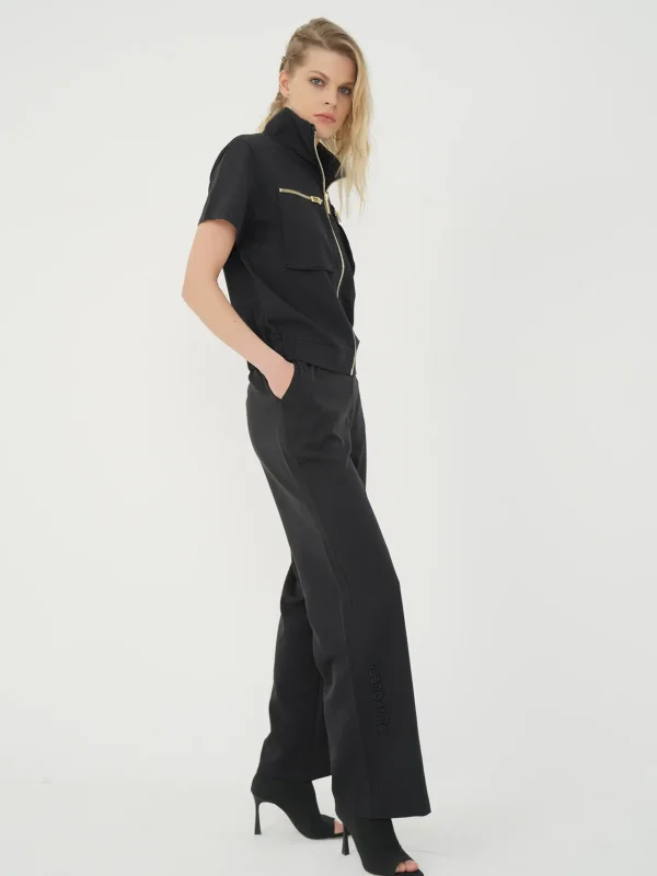 din profil, set negru cu jachetă cu guler înalt și pantaloni drepți largi