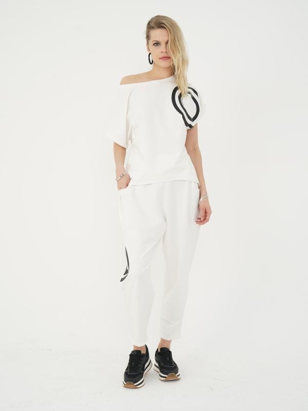 look sport-chic cu set ecru din bluză asimetrică cu umăr descoperit și pantaloni