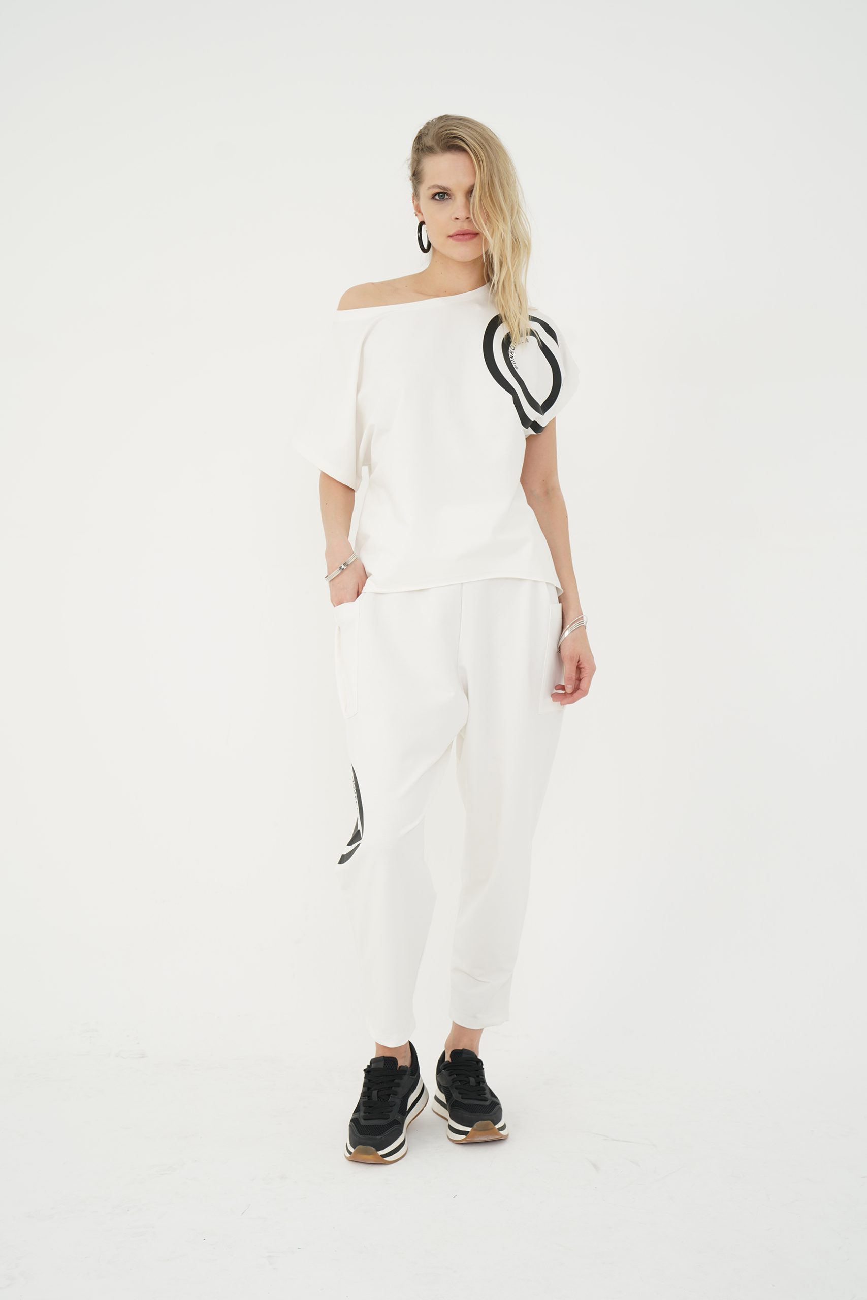 look sport-chic cu set ecru din bluză asimetrică cu umăr descoperit și pantaloni