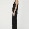 din profil, set negru cu vestă fără mâneci și pantaloni cu croială largă