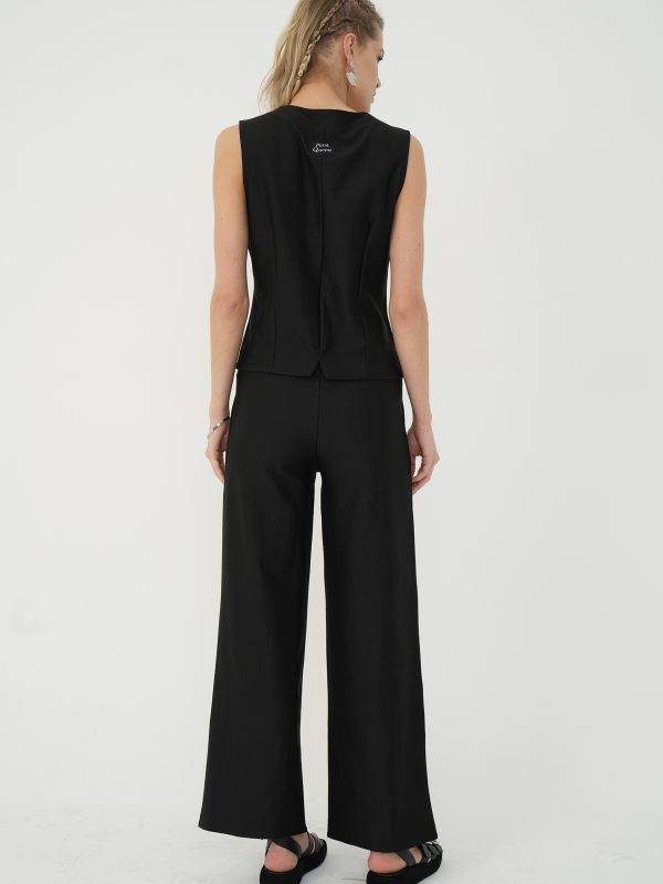 set negru cu vestă și pantaloni cu talie înaltă văzut din spate