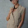 Femeie în ținută smart casual, cu costum bej.