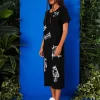 din profil, rochie neagră minimalistă cu slit lateral și tăietură simplă