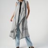 look urban-casual cu vestă lungă gri oversized peste un top și jeanși largi