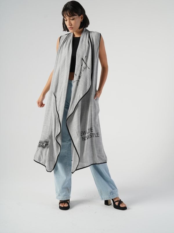 look urban-casual cu vestă lungă gri oversized peste un top și jeanși largi