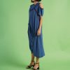 din profil, rochie albastră oversize cu umeri decupați și croială asimetrică