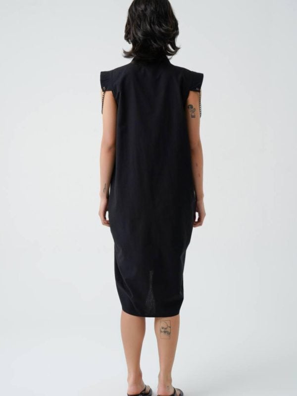 rochie neagră cu detalii urban-elegante văzută din spate, cu tiv asimetric