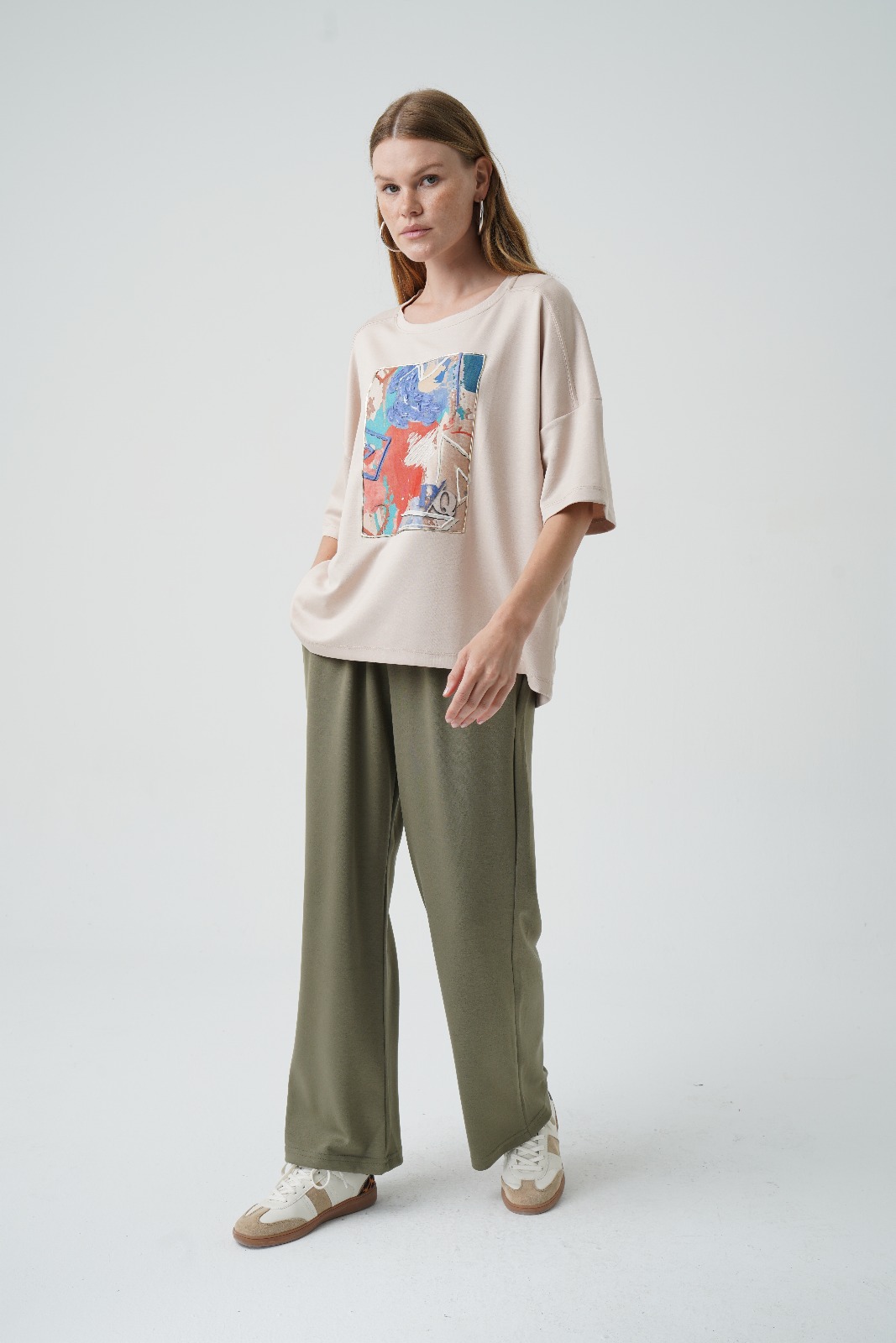 din profil, tricou oversized bej cu croială lejeră și imprimeu abstract