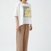 din profil, tricou oversized ecru cu croială lejeră și imprimeu galben