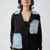 prim-plan cu aplicațiile din denim raw și inscripțiile de pe sacou