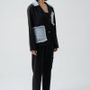 look de stradă cu costum negru cu aplicații denim și sneakers albi