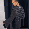 set negru cu bluză oversize și vestuță matlasată văzut din spate