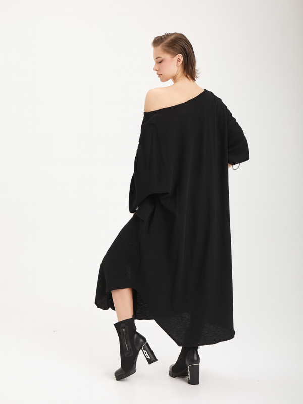 vedere din spate, femeie purtând o rochie oversize neagră cu print artistic pe un umăr