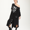 femeie purtând o rochie oversize neagră cu print artistic pe un umăr