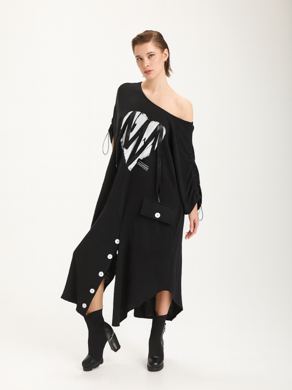 femeie purtând o rochie oversize neagră cu print artistic pe un umăr