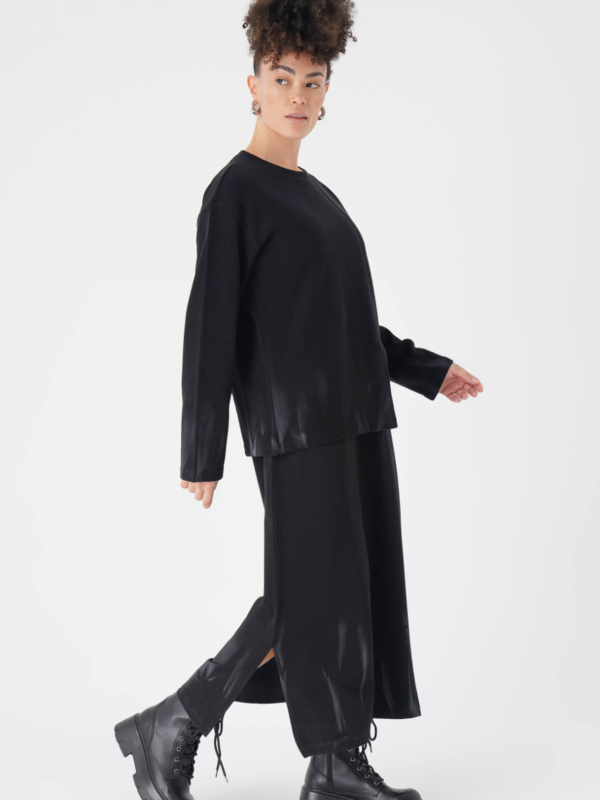 emeie purtând un set minimalist negru din rochie lungă și bluză