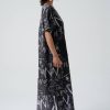 vedere din lateral, femeie purtând o rochie grafică oversized neagră cu sandale