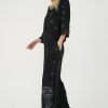 vedere din lateral, femeie purtând un set casual negru cu jachetă cu glugă și pantaloni largi