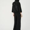 vedere din spate, femeie purtând un set casual negru cu jachetă cu glugă și pantaloni largi