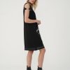vedere din lateral, femeie purtând o rochie punk neagră cu bocanci
