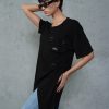 femeie cu ochelari de soare purtând un tricou asimetric negru cu umăr decupat