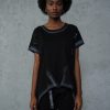 femeie purtând un set urban negru cu bluză asimetrică și pantaloni conici
