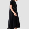 vedere din lateral, femeie purtând o rochie maxi neagră urbană cu pantofi